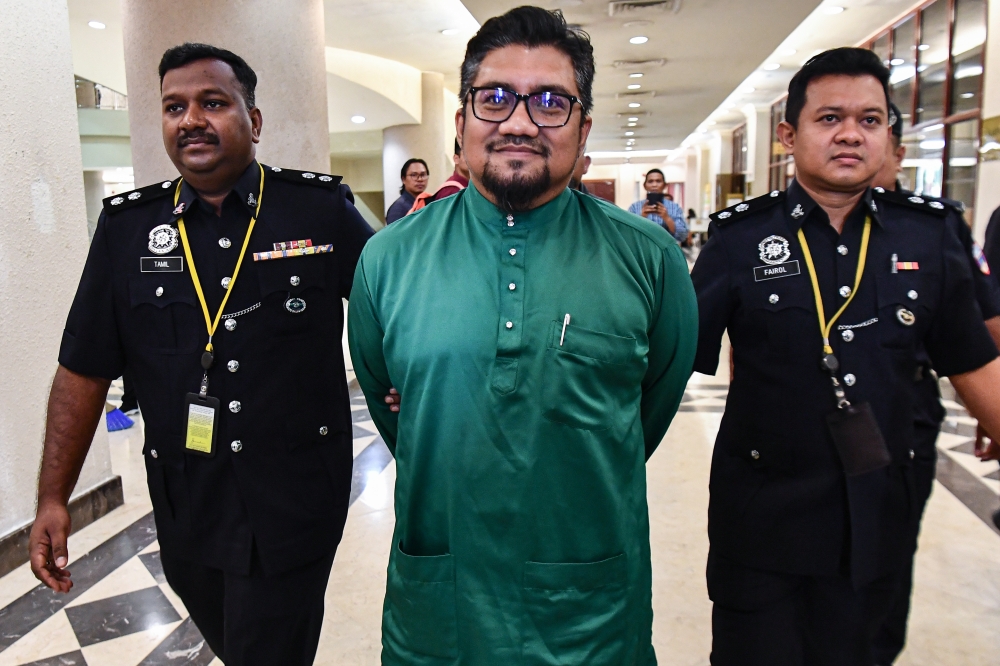 Bersatu Information Committee member Badrul Hisham Shaharin (centre) arrives at the Sessions Court in Kuala Lumpur April 29, 2024. — Bernama pic