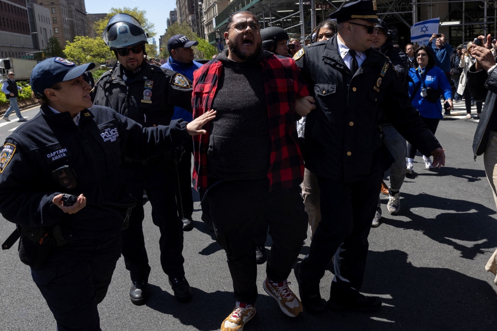 A demonstrator chanting ‘free Palestine’ is detained by police officers outside Columbia University campus as protests continue inside and outside Columbia University, amid the ongoing conflict between Israel and the Palestinian Islamist group Hamas, in New York City April 22, 2024. — Reuters pic  