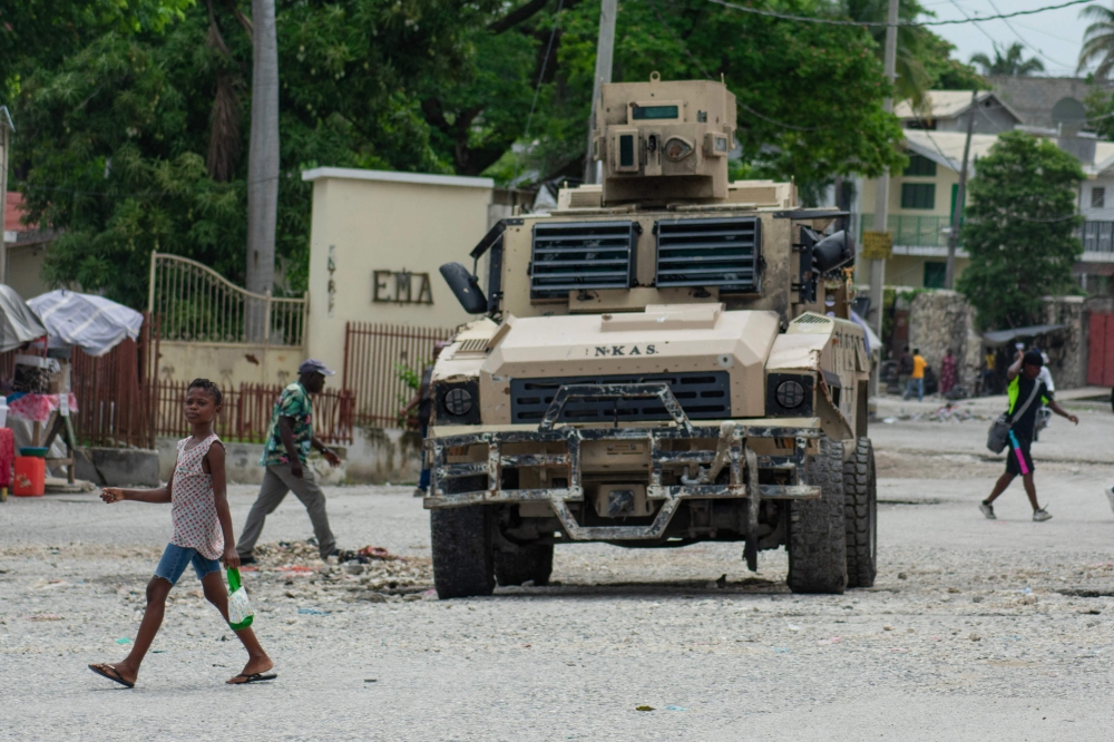 A child walks by a police vehicle in Port-au-Prince, Haiti, on April 26, 2024. A long-awaited transitional ruling council was sworn in on April 25 in Haiti, marking a critical step forward in restoring functional government in a country rocked by months of gang violence. — AFP pic