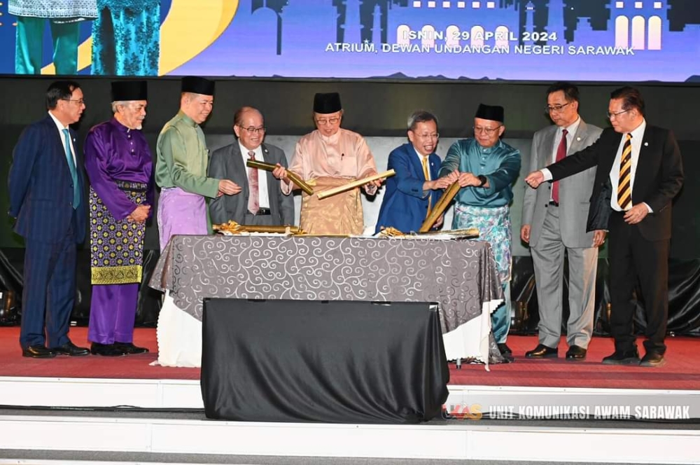 Abang Johari (centre) and Abu Bakar (third right) perform the opening gimmick for the event, assisted by Deputy Premiers Datuk Amar Douglas Uggah Embas (fourth left) and Datuk Amar Dr Sim Kui Hian (fourth right), and cabinet ministers and government officials.  —  Photo from Ukas