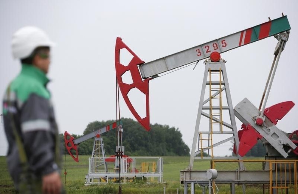 A worker looks at a pump jack at an oil field Buzovyazovskoye owned by Bashneft company north from Ufa, Bashkortostan, Russia July 11, 2015. — Reuters pic 