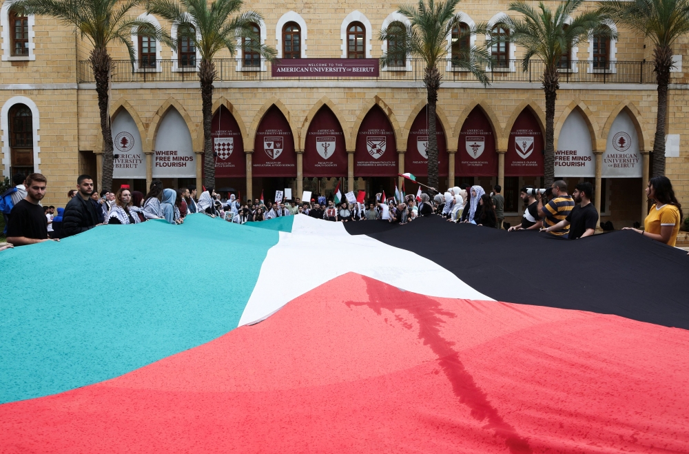 Demonstrators hold a Palestinian flag during a protest in solidarity with Gaza at the American University of Beirut (AUB), in Lebanon April 30, 2024. — Reuters pic
