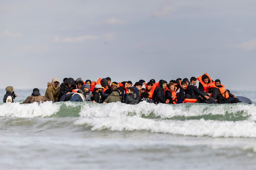 Migrants board a smuggler’s boat in an attempt to cross the English Channel, on the beach of Gravelines, near Dunkirk, northern France on April 26, 2024. — AFP pic