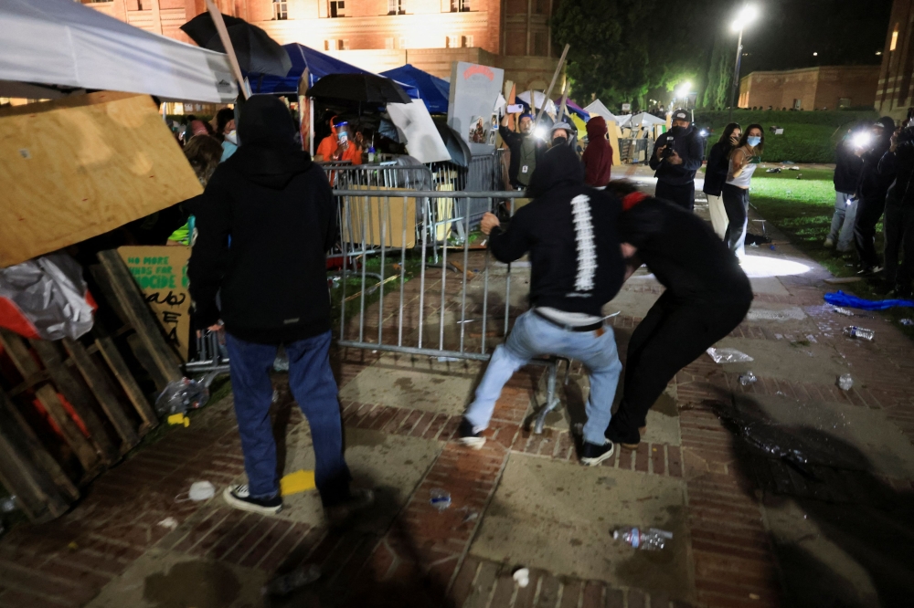 Counter-protesters attempt to move a barricade amidst clashes with protesters in support of Palestinians in Gaza at an encampment on the campus of the University of California Los Angeles (UCLA), amid the ongoing conflict between Israel and the Palestinian Islamist group Hamas, in Los Angeles May 1, 2024. — Reuters pic
