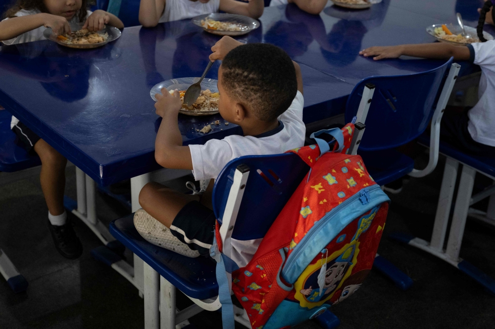 Students have lunch the municipal Burle Marx school’s kitchen in Rio de Janeiro, Brazil, on April 4, 2024. Nearly one-third of children in Brazil are obese, an epidemic city health officials and community leaders are seeking to address in innovative ways, enlisting school cafeterias and taking their message of healthful eating to the street. — AFP pic 