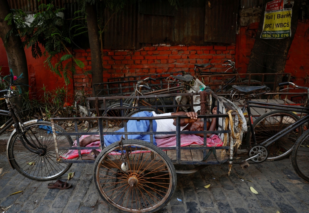 A man sleeps on his rickshaw by the roadside on a hot summer day in Kolkata, India, April 30, 2024. — Reuters pic