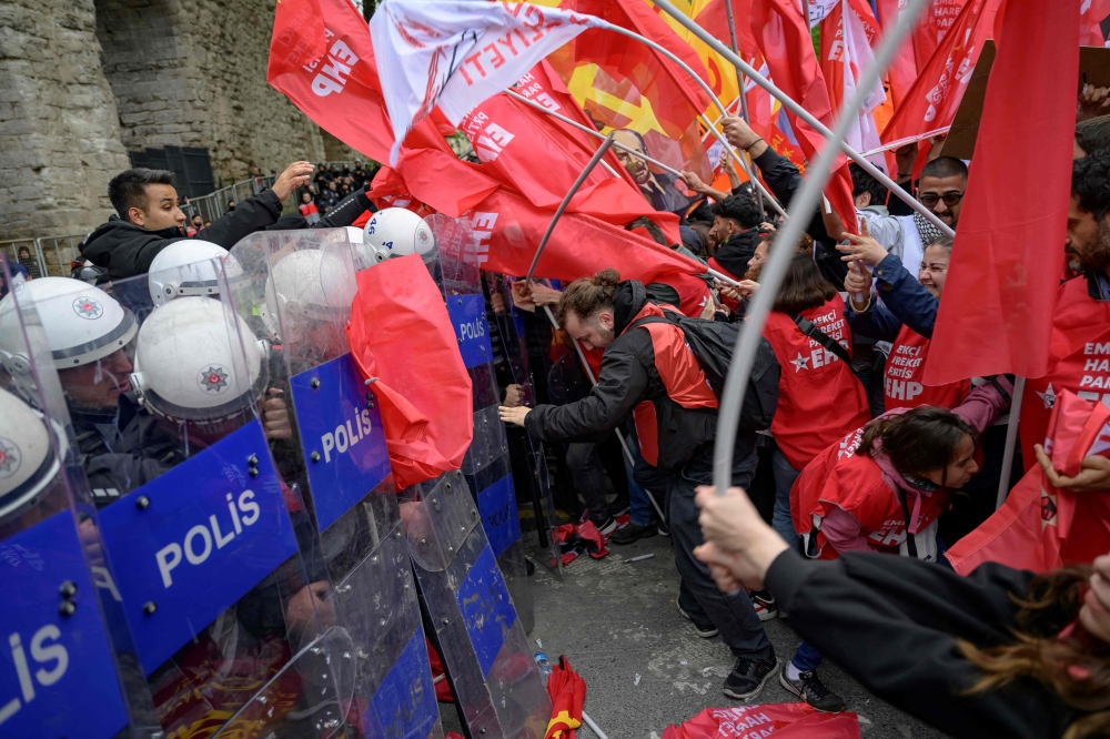 Protesters scuffle with riot police as they attempt to defy a ban and march on Taksim Square during a May Day (Labour Day) rally, marking International Workers' Day, at the Sarachane Park aqueduct in Istanbul, on May 1, 2024. — AFP pic