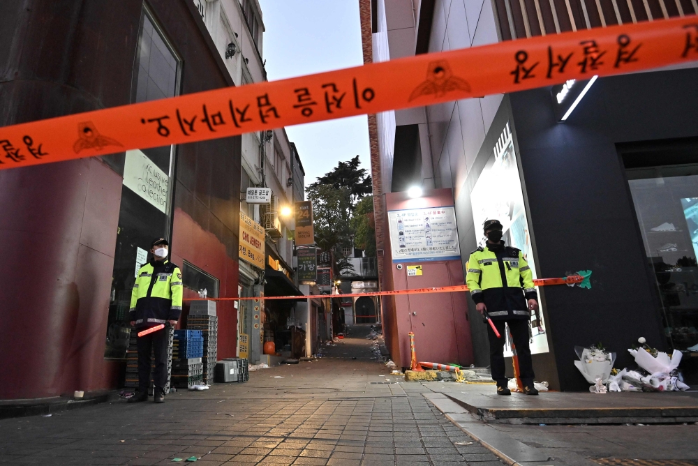 Police stand guard at the cordoned scene of the deadly Halloween crowd surge in the district of Itaewon in Seoul, November 1, 2022. — AFP file pic
