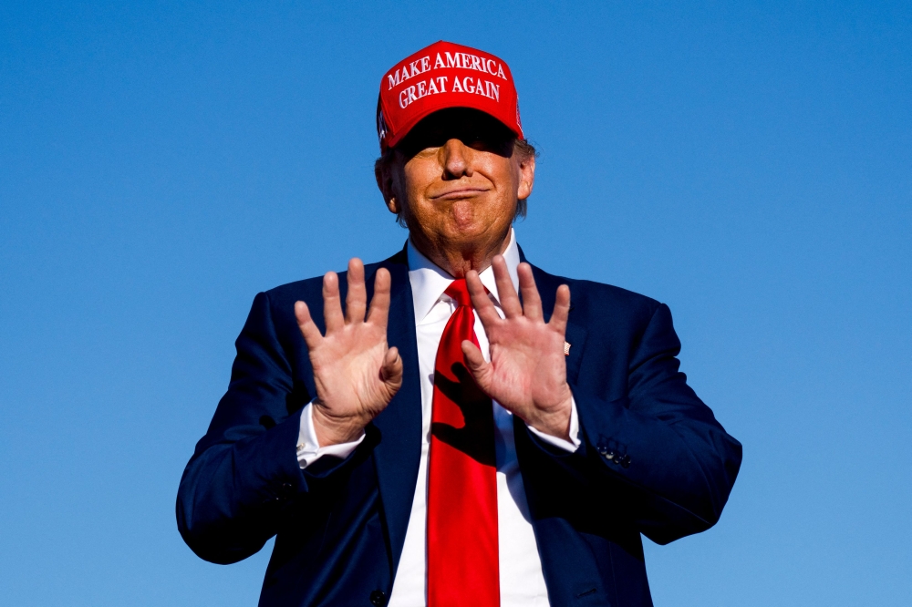 Republican presidential candidate, former U.S. President Donald Trump holds his hands up during a rally on May 1, 2024 at Avflight Saginaw in Freeland, Michigan. — AFP pic