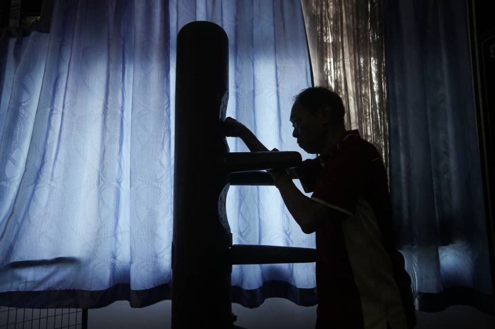 Perak Ku Kong Chow Association secretary Leong Chee Kong demonstrating how a wooden dummy is used. The dummy was used by Kwan when he was teaching martial arts at the association. — Picture by Farhan Najib