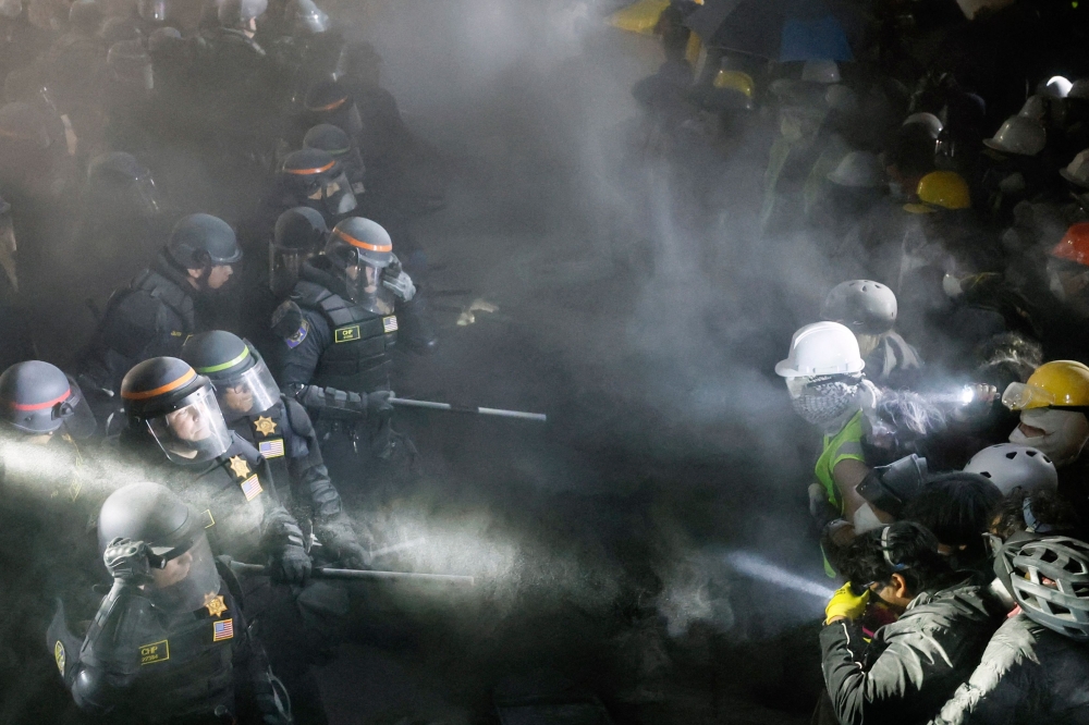 Police face-off with pro-Palestinian students after destroying part of the encampment barricade on the campus of the University of California, Los Angeles (UCLA) early yesterday. — AFP pic