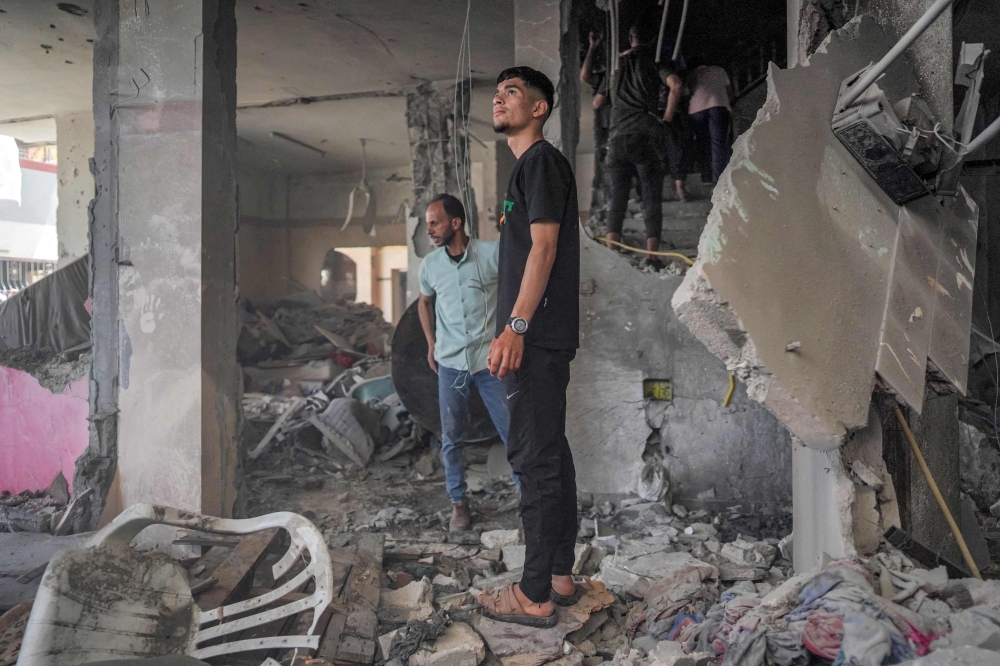 People search a building following Israeli strike in Nuseirat. — AFP pic