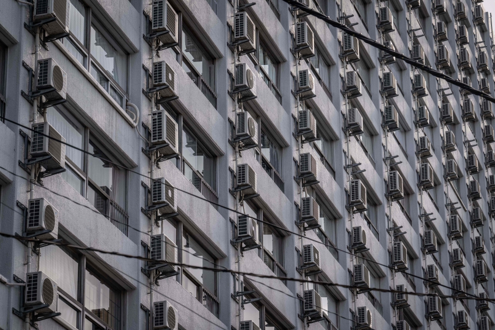 This picture taken on April 30, 2024 shows air conditioning units on an apartment building in Tokyo. A record-breaking heatwave is broiling parts of Asia, helping drive surging demand for cooling options, including air-conditioning. — AFP pic