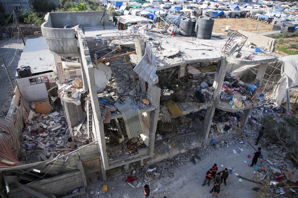 People stand next to a house damaged in an Israeli strike, amid the ongoing conflict between Israel and the Palestinian Islamist group Hamas, in Rafah, in the southern Gaza Strip May 3, 2024. — Reuters pic  