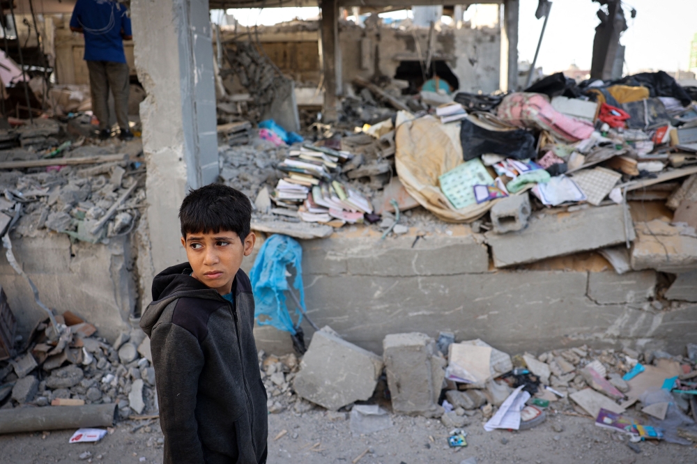 A Palestinian child stands in front of a building destroyed by Israeli bombing in Rafah in the southern Gaza Strip on May 3, 2024, amid the ongoing conflict between Israel and the Hamas movement. — AFP pic