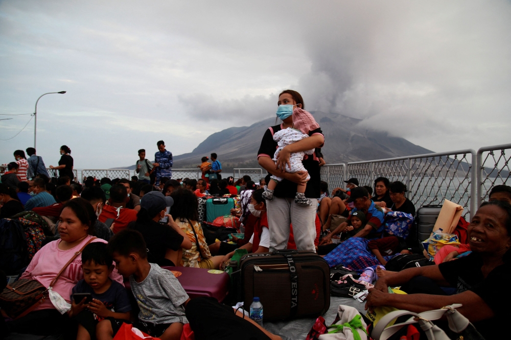 A woman carrying her child stands on the deck of KRI Kakap-881 warship, as people are being evacuated to North Minahasa Regency on Sulawesi island, following the eruptions of Mount Ruang volcano in Sitaro, North Sulawesi province, Indonesia, May 1, 2024, in this photo taken by Antara Foto. — Antara Foto pic via Reuters 
