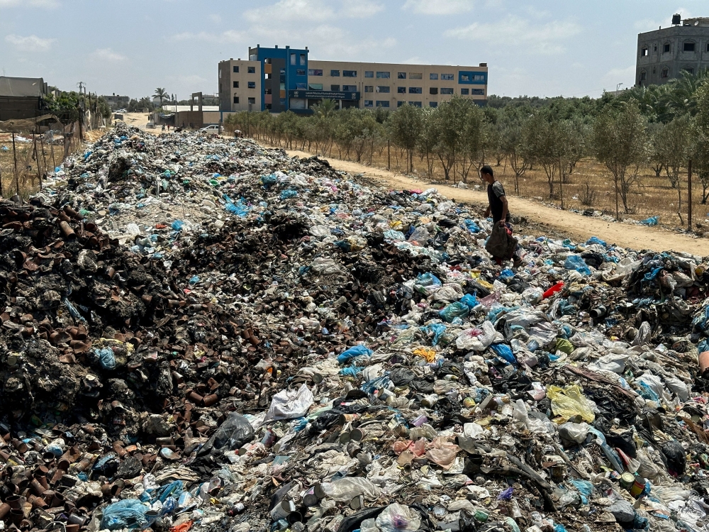 A Palestinian man walks on piles of garbage, amid the ongoing conflict in Gaza between Israel and Hamas, at Deir Al-Balah, in the central Gaza Strip, May 2, 2024. ― Reuters pic