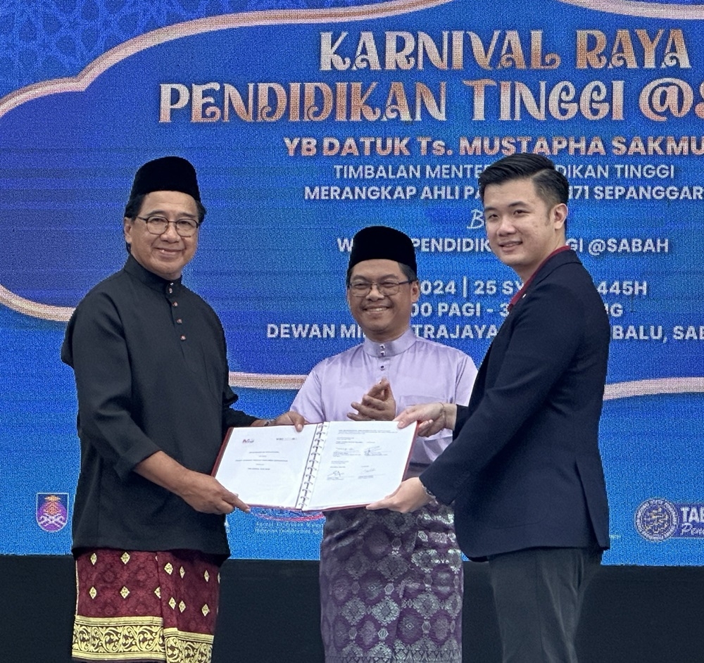 Deputy Higher Education Ministry Datuk Mustapha Sakmud (centre) witnesses the MoU exchange between Sepanggar parliamentary office director Ahsim Jamat (left) and Uni Enrol chief executive officer Rickson Khaw. — The Borneo Post pic 