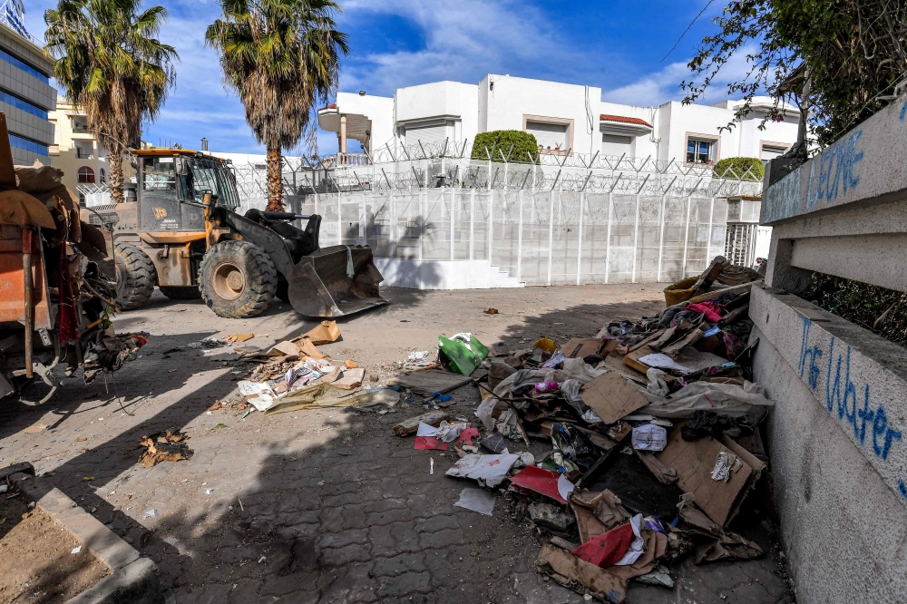 A bulldozer clears debris outside the International Organisation for Migration (IOM) headquarters in Tunis on May 3, 2024 after the local authorities removed an encampment that was erected there by migrants in a forced evacuation. ― AFP pic