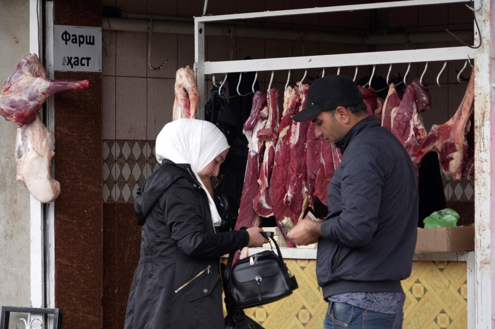 A woman buys lamb meat at a market in the town of Hissar, western Tajikistan March 27, 2024. — AFP pic