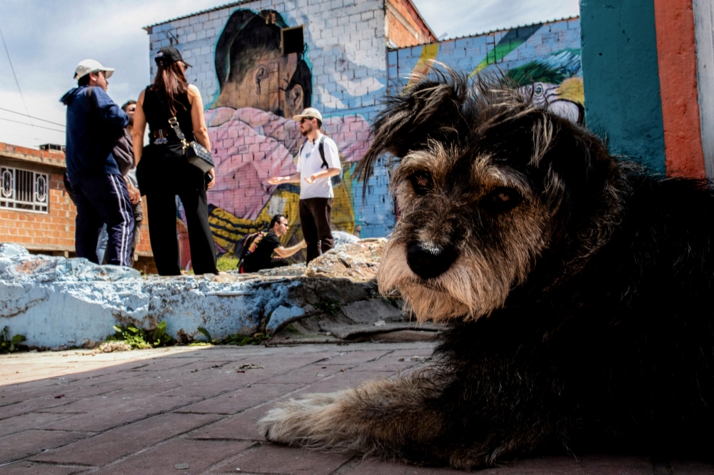 The tourist guide May Rojas (centre) talks with tourists during a tour of the Ciudad Bolivar neighbourhood in Bogota April 14, 2024. — AFP pic