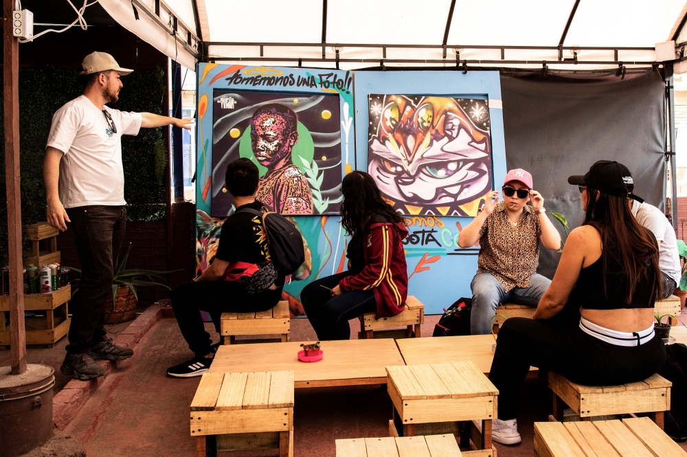 The tourist guide May Rojas (left) talks with tourists during a tour of the Ciudad Bolivar neighbourhood in Bogota April 14, 2024. — AFP pic