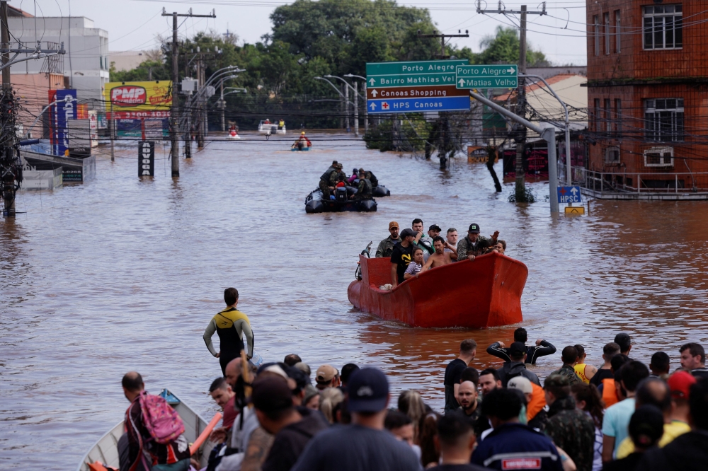 Authorities in southern Brazil scrambled yesterday to rescue people from raging floods and mudslides that have killed at least 75 and forced more than 88,000 to flee their homes. — Reuters pic