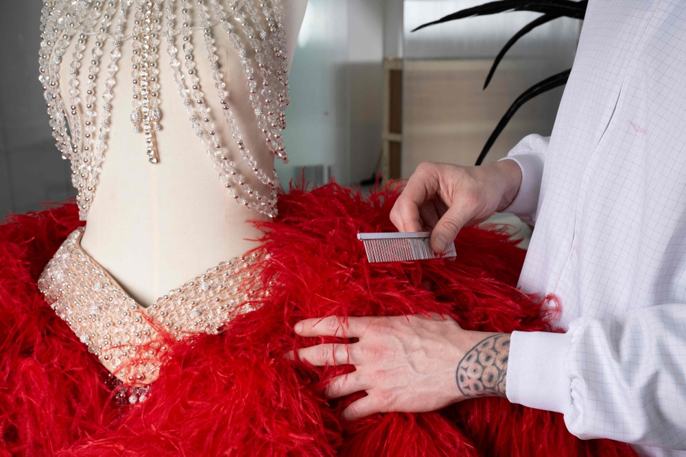 Director of the atelier of Maison Fevrier Maxime Leroy works on plumasserie (fine feather work) dedicated to the costumes of the dancers at the Moulin Rouge musical cabaret in Paris on March 21, 2024. — AFP pic