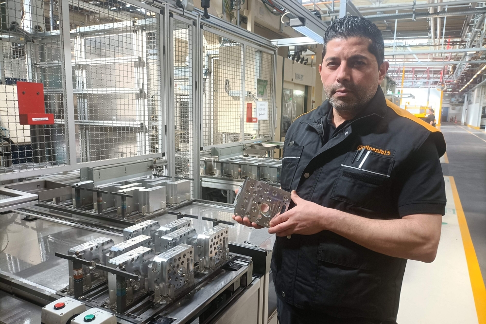 Emrullah Karaca checks hydraulic valve blocks at his work place at the  Continental Automotive Technologies' plant in Gifhorn, Germany, on April 23, 2024. — AFP pic
