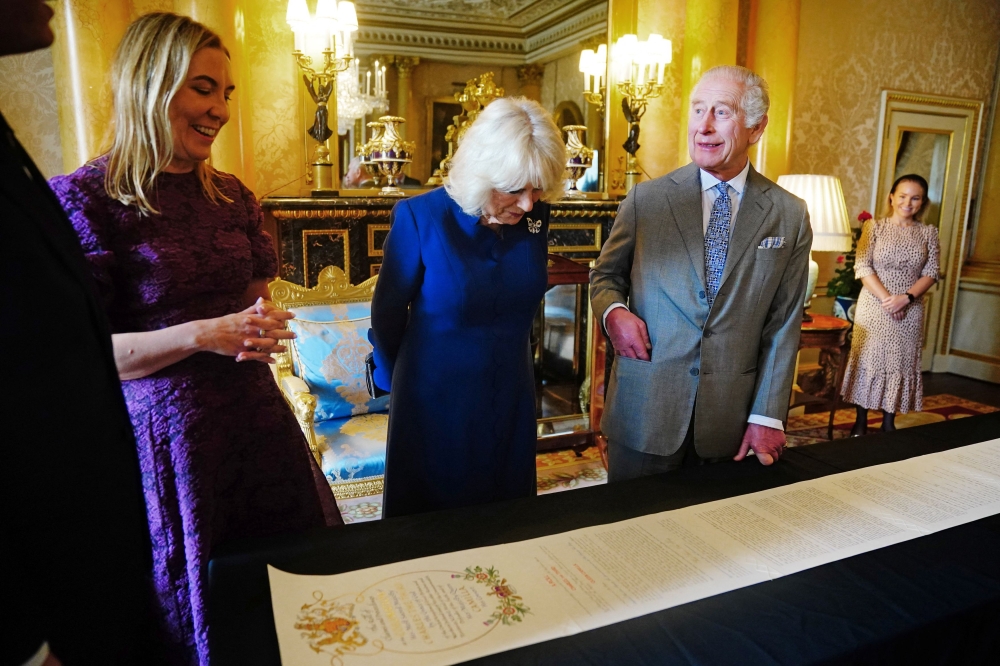 Britain's King Charles and Queen Camilla are presented with the Coronation Roll, an official record of their Coronation, by the Clerk of the Crown in Chancery, Antonia Romeo, at Buckingham Palace, central London May 1, 2024. — Victoria Jones/Pool/Reuters pic