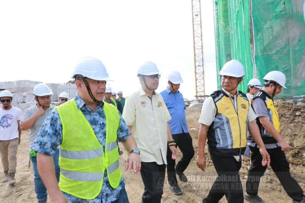 Nanta (left) together with JKR officials inspecting the site of the government quarters construction project. ― The Borneo Post pic