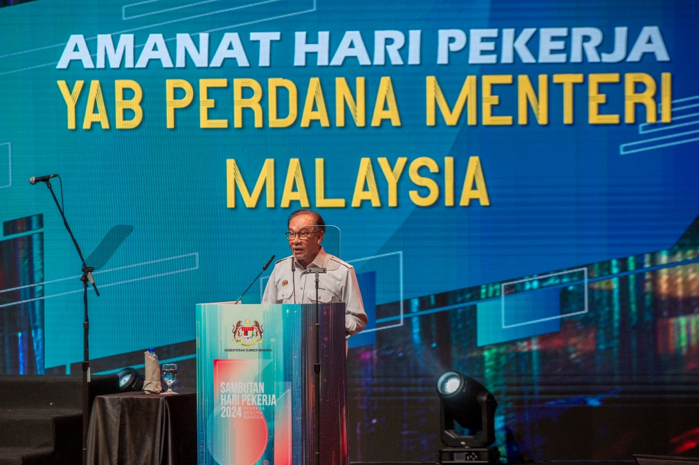 Prime Minister Datuk Seri Anwar Ibrahim delivers his keynote address during the National Labour Day celebration at Putrajaya International Convention Centre (PICC) in Putrajaya, May 1, 2024. Anwar announced the hike at the celebration, where he suggested the increment would likely be more than 13 per cent as part of a wider civil service pay system revamp that would see the floor rate raised to a minimum of RM2,000. — Picture by Shafwan Zaidon