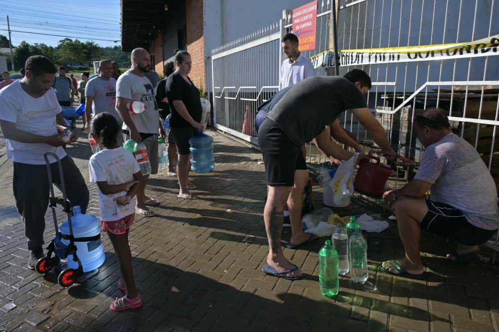 Teams in flood-ravaged southern Brazil scrambled yesterday to deliver humanitarian aid to Porto Alegre and other inundated municipalities, where queues formed for drinking water as forecasters warned of more downpours. — AFP pic