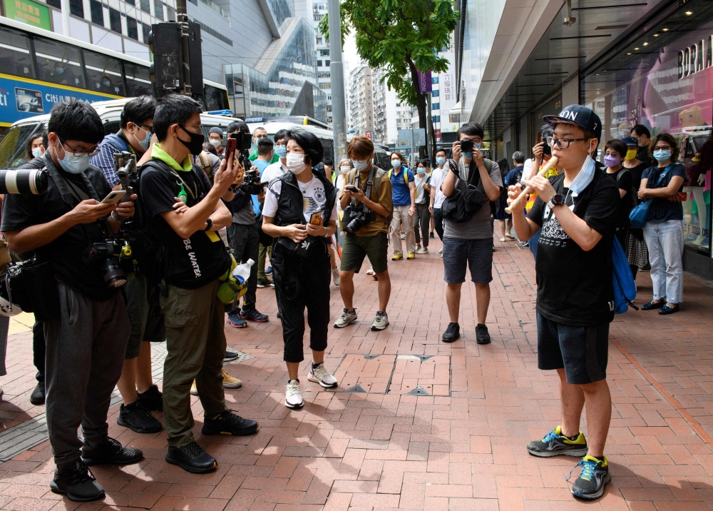This photo taken on October 1, 2020 shows a man playing “Glory to Hong Kong” on a flute during the China’s National Day in Hong Kong. — AFP file pic