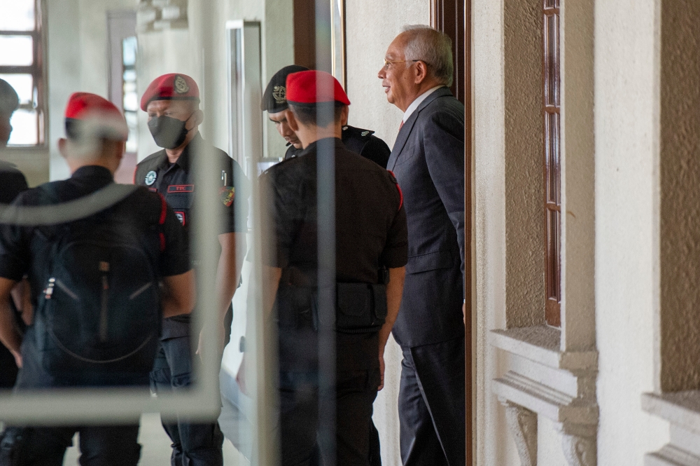 Former premier Datuk Seri Najib Razak escorted to the court room for the SRC International case at Kuala Lumpur Court Complex, May 8, 2024. —  Picture by Shafwan Zaidon