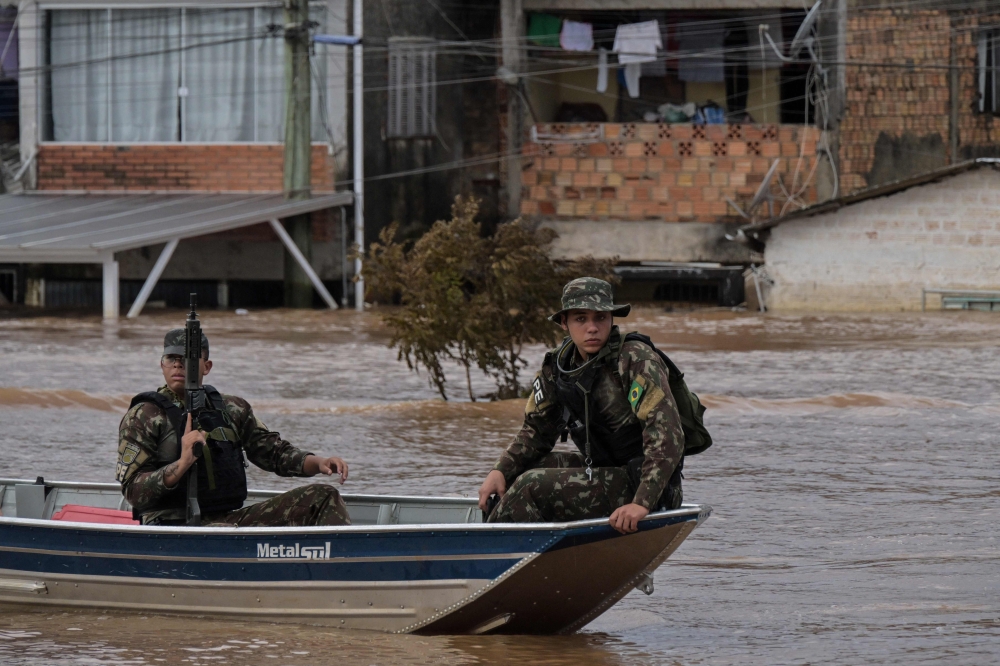 Army soldiers patrol the flooded Humaita neighbourhood in Porto Alegre. — AFP pic
