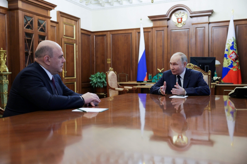 Russian President Vladimir Putin speaks with Prime Minister Mikhail Mishustin, who was reappointed as head of the country’s government today. — AFP pic