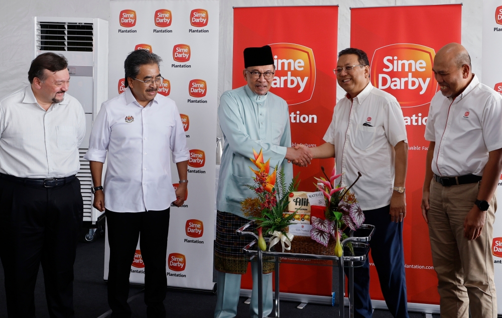Prime Minister Datuk Seri Anwar Ibrahim (centre) and Sime Darby Plantation chairman Tan Sri Nik Norzrul Thani Nik Hassan Thani (2nd right) shake hands during a visit to the Sime Darby Plantation’s operation site at Pulau Carey May 10, 2024. — Bernama pic