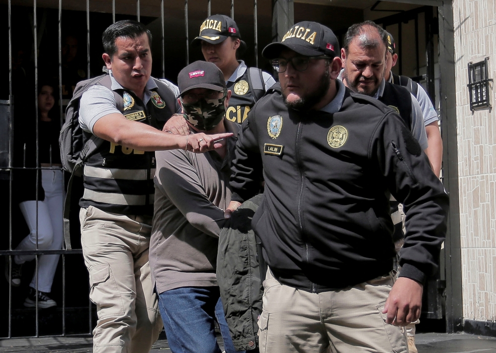 Police officers escort Nicanor Boluarte, brother of Peruvian President Dina Boluarte, as he leaves his home, after prosecutors detained him for allegedly being part of a group that trafficked influence, according to the Attorney General's Office, in Lima, Peru May 10, 2024. — Reuters pic