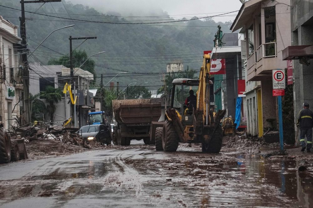 A worker cleans a street with a backhoe loader after the floods caused by heavy rains in Mucum, Rio Grande do Sul state, Brazil May 10, 2024. — AFP pic