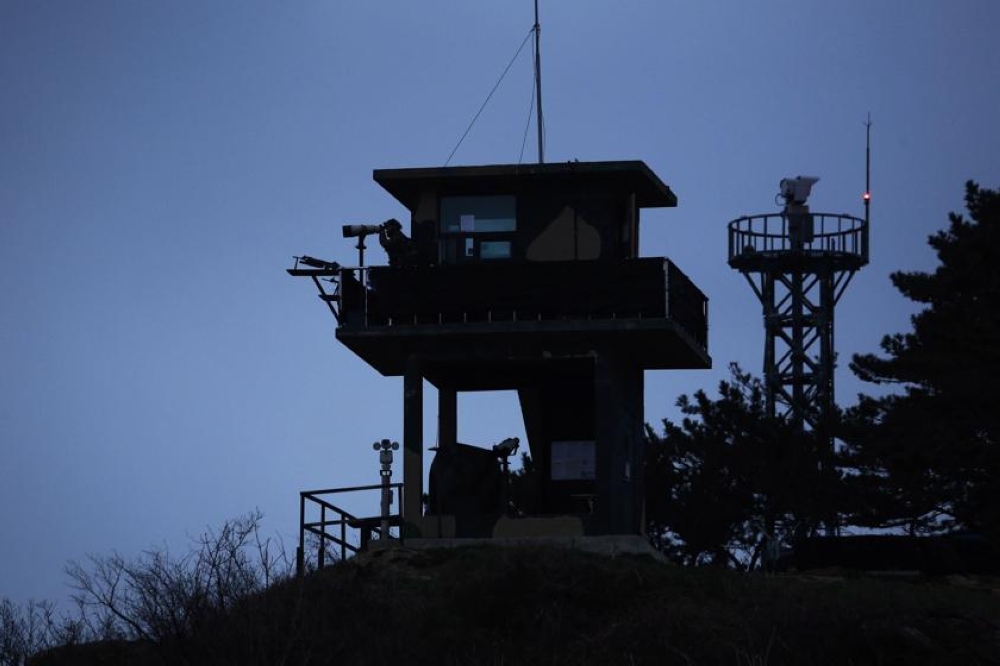 File photo of a South Korean soldier using binoculars to look out to sea from a watchtower on the Yeonpyeong island, which lies just inside the South Korean side of the Northern Limit Line (NLL) in the Yellow Sea April 8, 2014. - Reuters pic