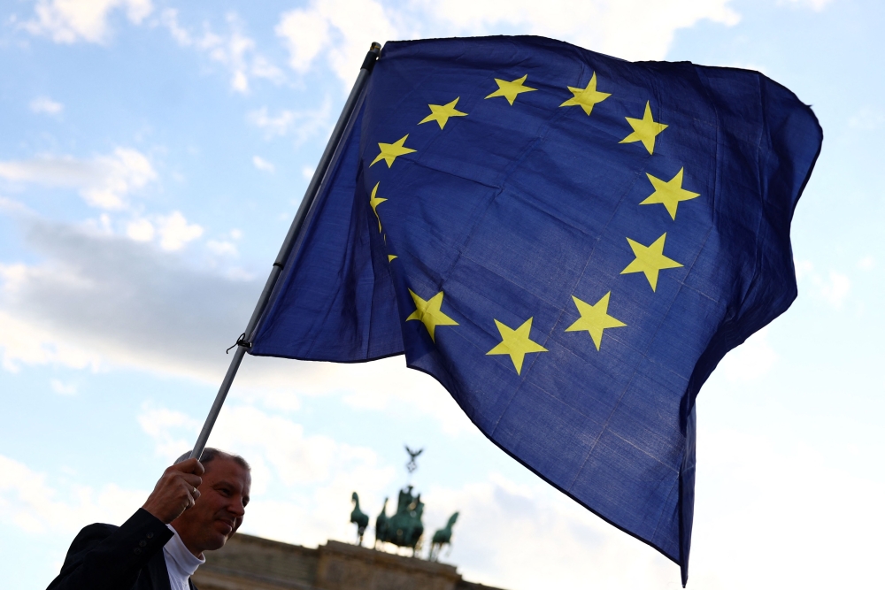 File photo of a participant displaying the flag of the European Union during a demonstration against the far right and to condemn attacks on politicians, in front of the Brandenburg Gate in Berlin, Germany on May 5, 2024. — AFP pic