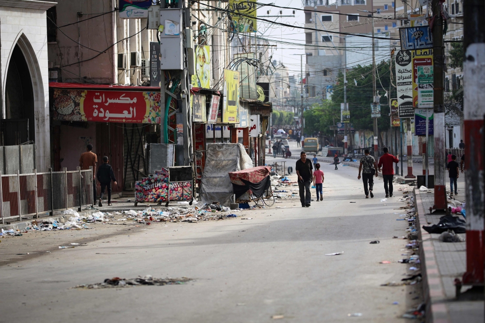 People walk along a nearly deserted street in Rafah in the southern Gaza Strip on May 11, 2023, amid the ongoing conflict between Israel and Hamas. — Reuters pic