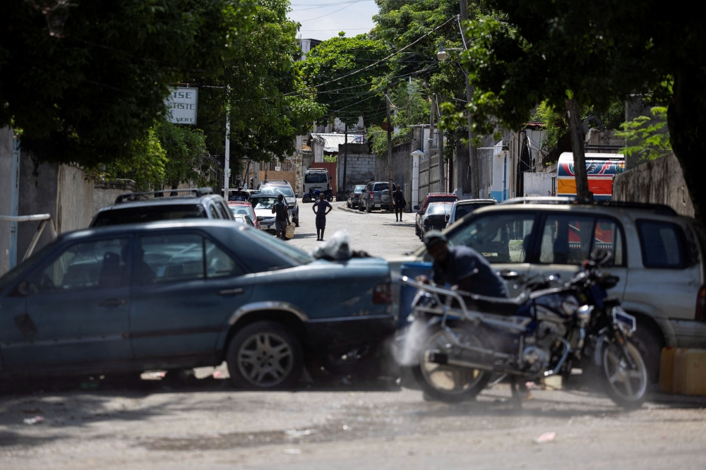 A view of a makeshift barricade built by residents out of abandoned vehicles to block a road and prevent gangs from entering their community. — Reuters pic