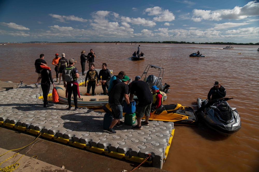 Volunteer rescuers refuel their boats and jet skis at an improvised dock in Porto Alegre. — AFP pic