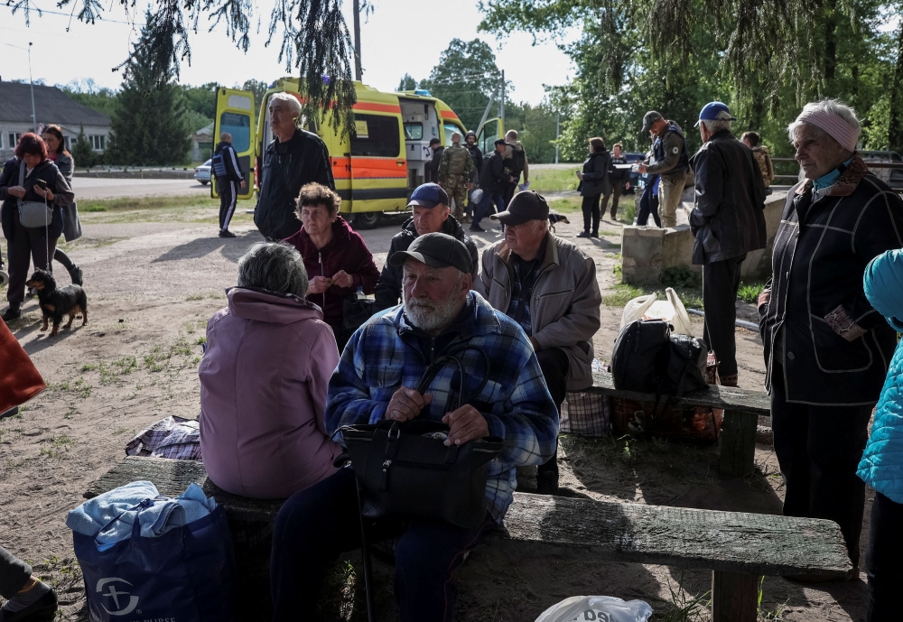 Residents from Vovchansk and nearby villages wait for buses to evacuate Kharkiv due to Russian shelling. — Reuters pic