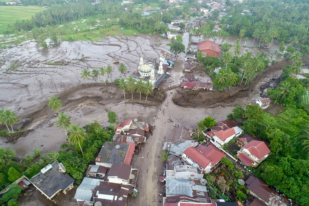 This handout aerial image taken and released by Indonesia's Disaster Mitigation Agency (BNPB) on May 12, 2024, shows the damaged area after flash floods and cold lava flow from a volcano in Tanah Datar, West Sumatra. At least 34 people have died and 16 more were missing after flash floods and cold lava flow from a volcano hit western Indonesia, a local disaster official said on May 12. — Indonesia Disaster Mitigation Agency via AFP