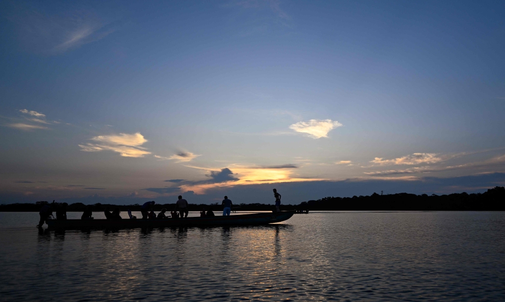 Tourist enjoy the sunset at Laguna Grande in the protected Amazon rainforest of Cuyabeno, Ecuador March 27, 2024. — AFP pic