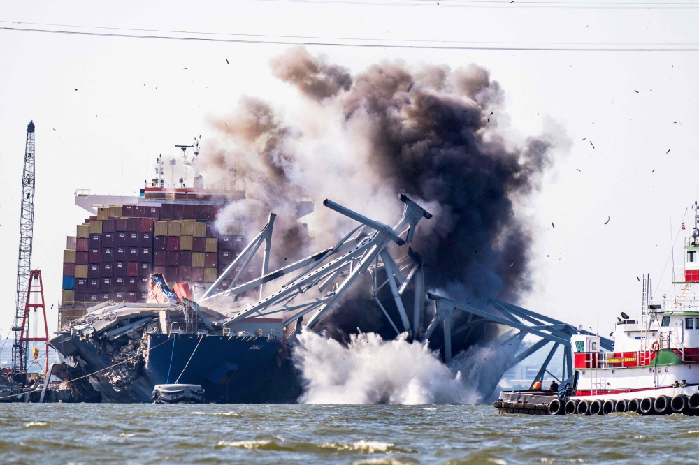 Demolition experts used explosives yesterday to remove part of a collapsed bridge in Baltimore and free a cargo ship that has been trapped since it rammed into the structure in March. — AFP pic