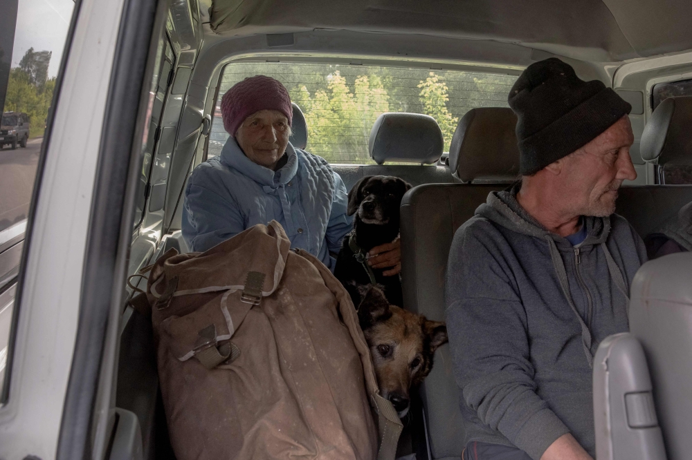 Evacuees from villages of Kharkiv region wait in a car at a checkpoint outside Kharkiv. — AFP pic